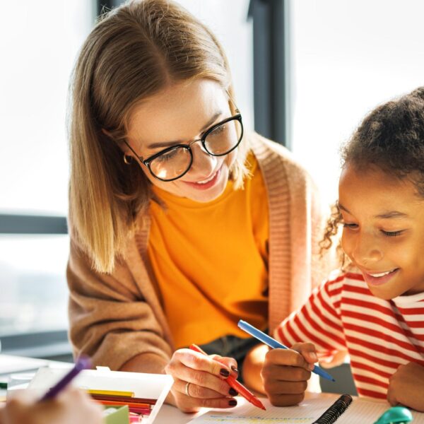 Teacher helping children with schoolwork