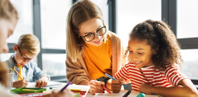 Teacher helping children with schoolwork
