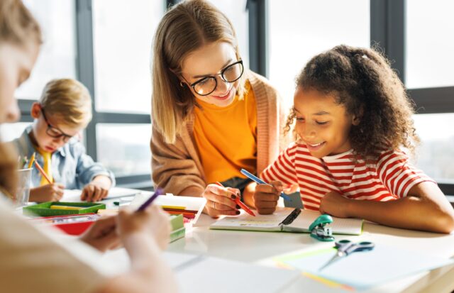 Teacher helping children with schoolwork