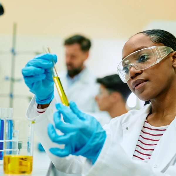 Chemistry student working in laboratory holding test tubes