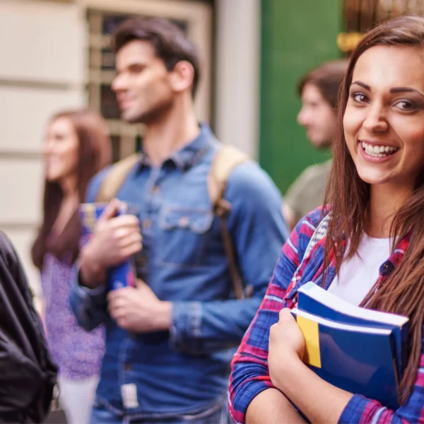 Female student holding books smiling at camera