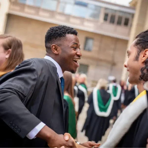 Graduation day with student shaking hands with another student