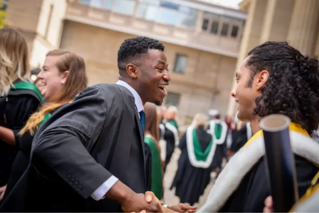 Graduation day with student shaking hands with another student