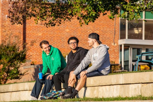 3 students at Mercy sat outside talking