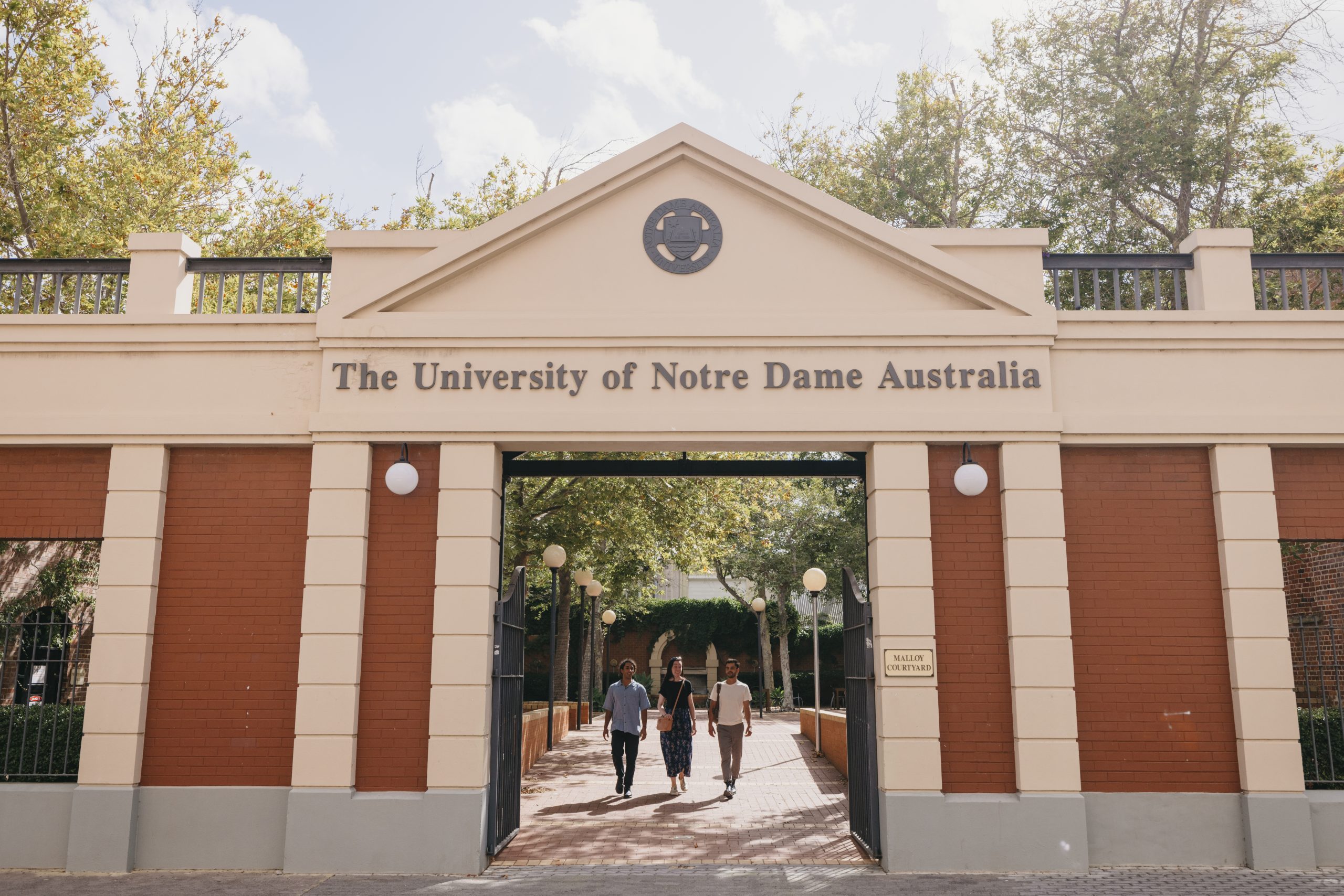 UNDA entrance with three students walking through