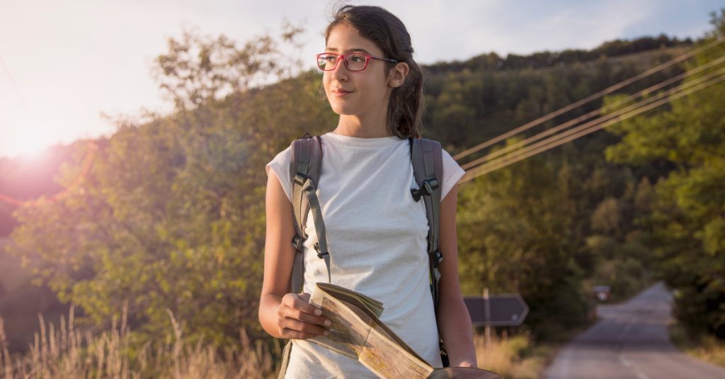 Student with backpack and map on a walk