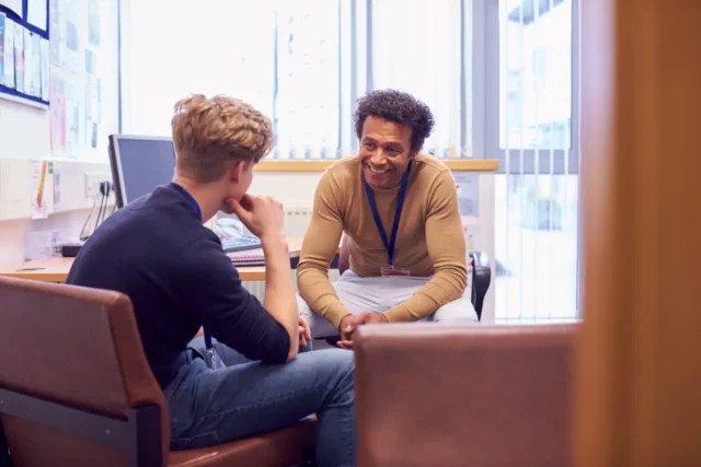 Lecturer in office talking to student
